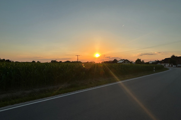 Straße im Sonnenaufgang mit Lichtstrahl – Symbol für die energetische Transformation von Trotz zu Klarheit und innerer Kraft