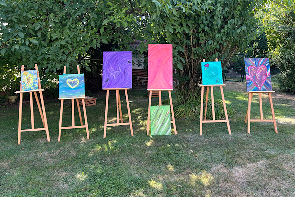 Seelenbilder auf Staffeleien im Garten, in den verschiedensten Farben.