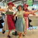 Gruppenfoto von Heidi, Claudia und Anita im Dirndl mit farbigen Hüten und ausgestreckten Armen.