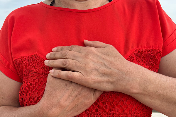 Nahaufnahme von Anita Griebls Oberkörper mit Händen auf dem Herzen – ein Moment des bewussten Fühlens und Lösens alter Emotionen.