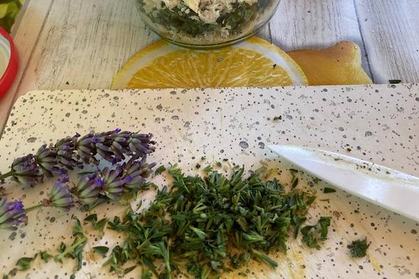 Geschnittene Kräuter, Lavendel und geriebener Meerrettich auf einem Holzbrett – natürliche Zutaten voller Pflanzenkraft.