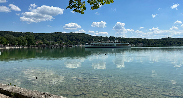 Ruhiger See mit weiter Landschaft im Hintergrund, ein stiller Moment, der Leichtigkeit und innere Weite symbolisiert.